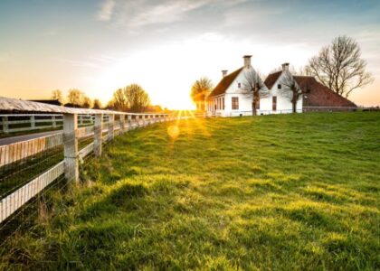 Tenuta agricola immersa nel verde al tramonto, esempio di agri-turismo sostenibile e autentico contatto con la campagna 4.0.
